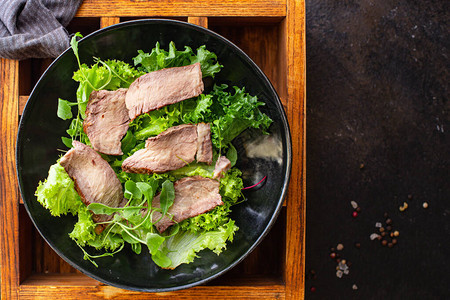 餐桌上的小牛肉切片仍维持着美味的鱼肉或白菜食物背景生动版面图片