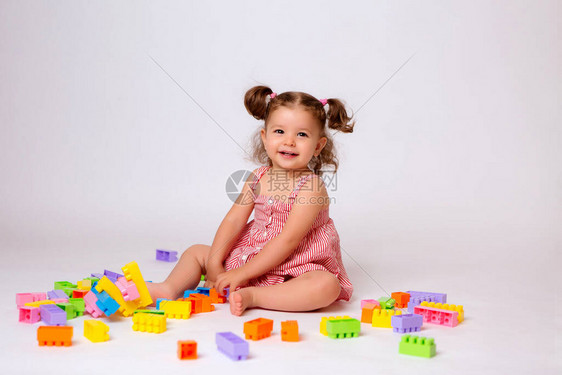 可爱的小女孩穿着粉色连衣裙带乐高积木图片