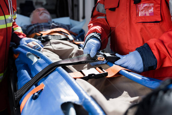 救护人员在救护车旁担架上靠近病人的有选择地图片