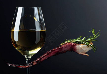 黑色背景的灰色章鱼和白葡萄酒图片