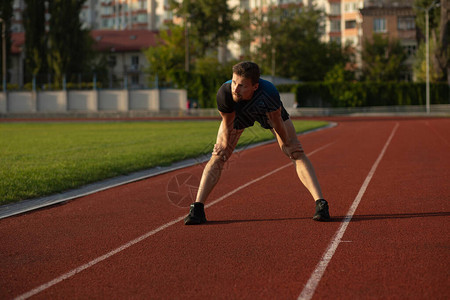 健身男穿运动服准备在体育场慢跑图片
