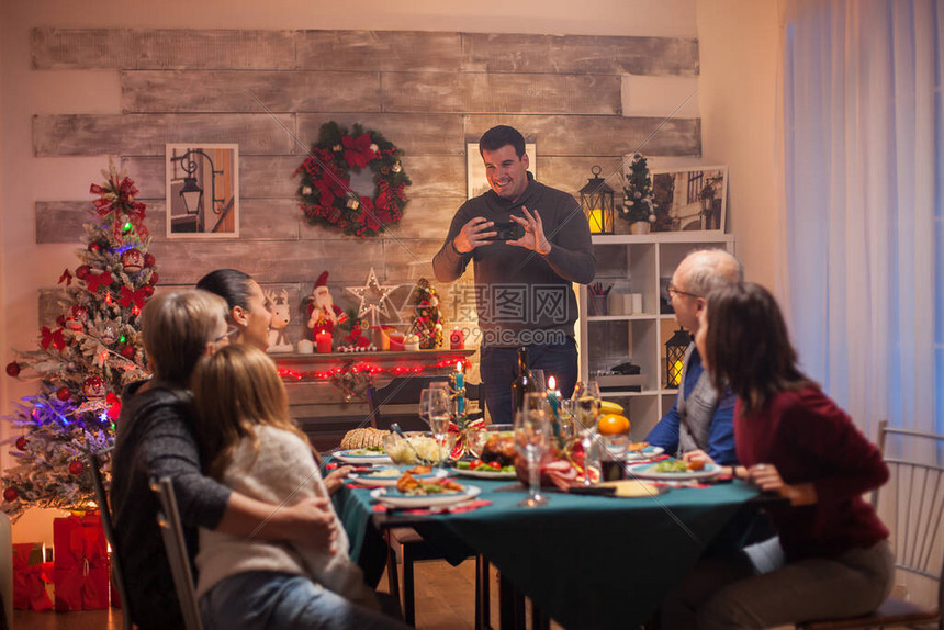 利用智能手机拍摄家人在圣诞节庆典的照片图片
