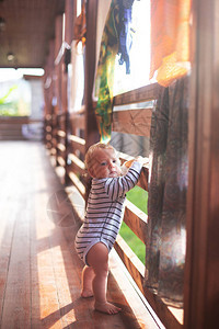 男婴在阳光明媚的早晨迈出第一步男孩在阳光下赤脚站在乡间别墅外面干布在背景上舒适温暖的心图片