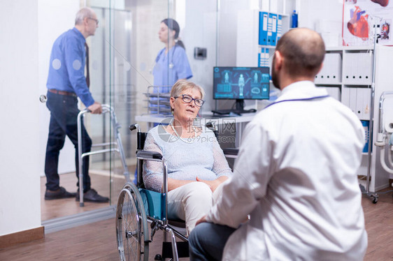 医生在医院检查室咨询坐在轮椅上的残疾妇女图片