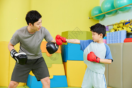 小男孩和教练一起进行拳击训练图片