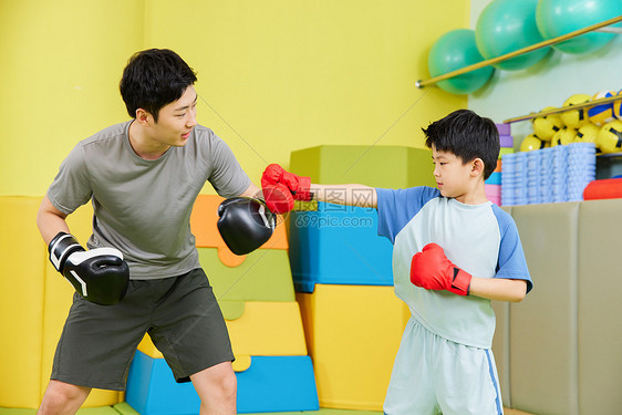 小男孩和教练一起进行拳击训练图片