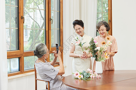优雅的老年女性聚会一起插花拍照高清图片