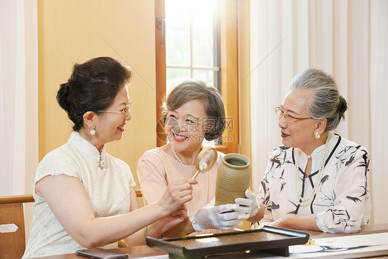 老年女性聚会一起鉴赏古董图片