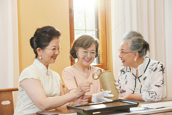 老年女性聚会鉴赏古董图片