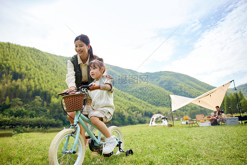 户外露营妈妈教女儿骑自行车图片