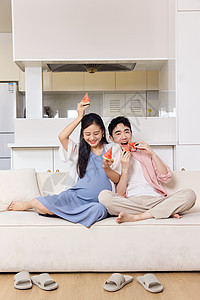 青年待产的夫妻居家吃西瓜开心互动图片