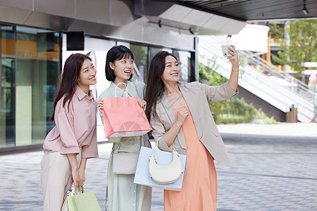 逛街购物的女性使用手机合照图片