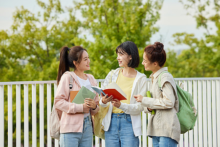 秋季校园户外校园看书的大学生背景