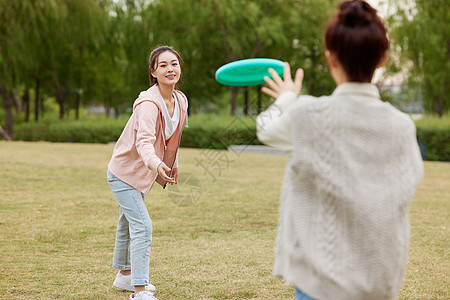 秋季在户外玩飞盘的女性图片