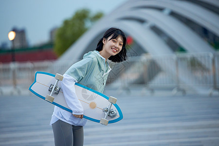 户外玩滑板的年轻女性高清图片