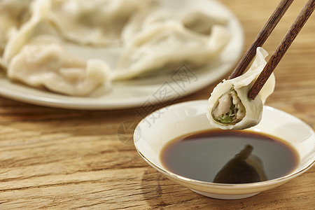 筷子夹起水饺蘸醋特写背景图片