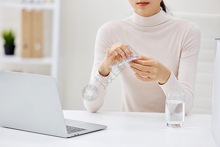 生病吃药的职场女性特写图片