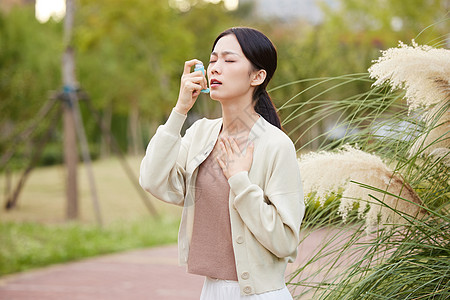 使用喷雾女性室外使用哮喘喷雾背景