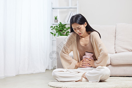 坐着美女经期肚子疼的居家女性背景