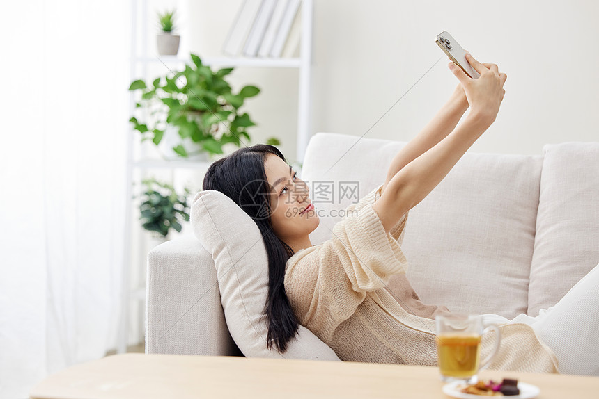 假日居家女性使用手机自拍图片