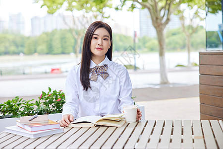 年轻女学生户外阅读学习图片