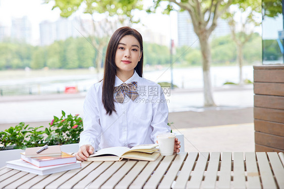 年轻女学生户外阅读学习图片