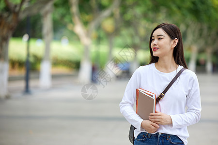 女青年校园里抱着书本图片