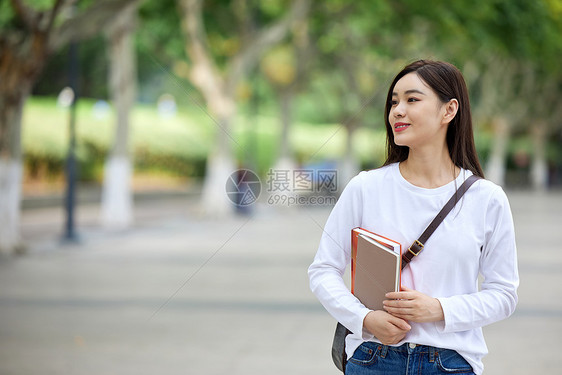 女青年校园里抱着书本图片