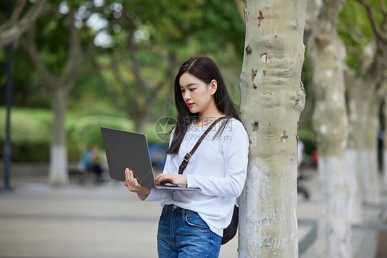 女大学生手捧笔记本电脑图片