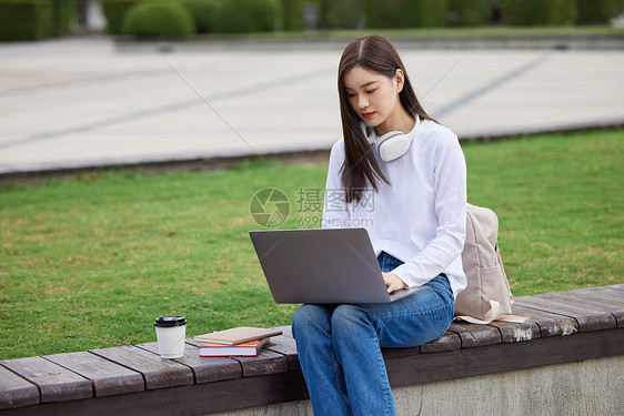 年轻美女大学生户外上网课图片