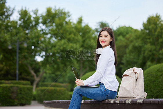 女青年手捧笔记本电脑图片