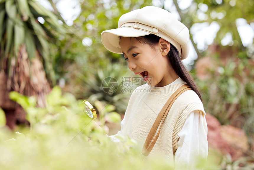 在植物园使用放大镜的小女孩图片