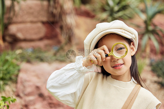 在植物园手拿放大镜的小女孩图片