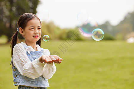 秋季室外玩泡泡的小女孩图片