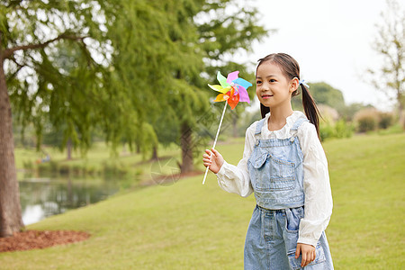 秋季室外手拿风车玩耍的小女孩图片