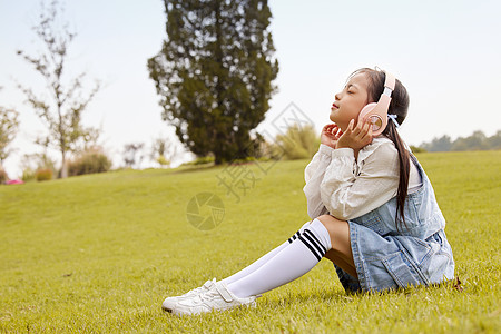 金色耳机草地上戴着耳机的儿童背景