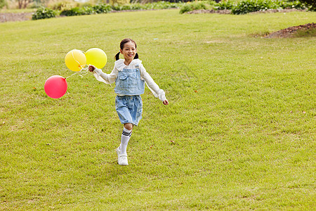 户外手拿气球奔跑的小女孩图片