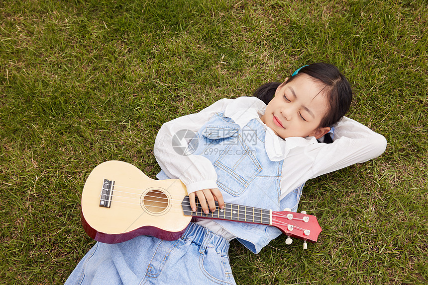 可爱儿童躺在草坪上休息图片