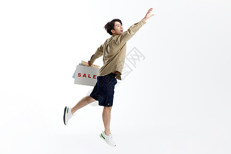 跳跃的男性手提购物袋形象图片