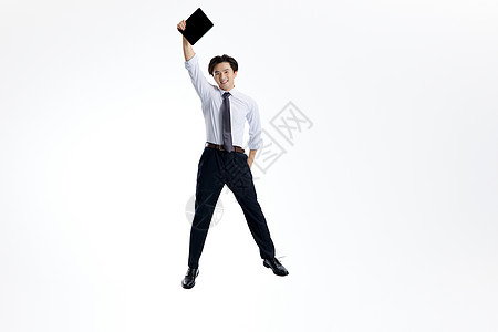 跳跃的商务男士手举平板电脑背景图片