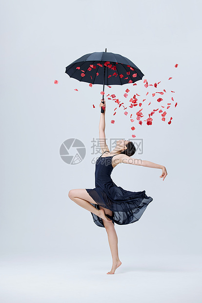 撑伞花瓣舞蹈的女性图片