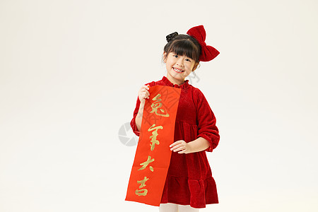 春节兔年对联身穿红衣服的小女孩双手拿春联背景