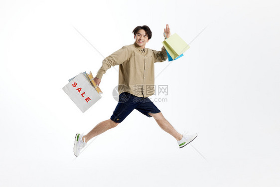 跳跃的男性手提购物袋形象图片