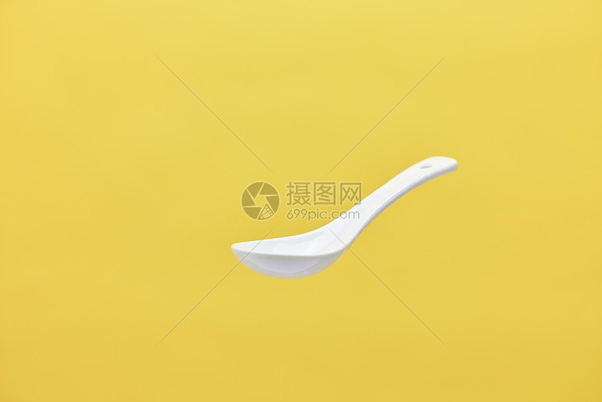 在空中漂浮的白色陶瓷勺子图片