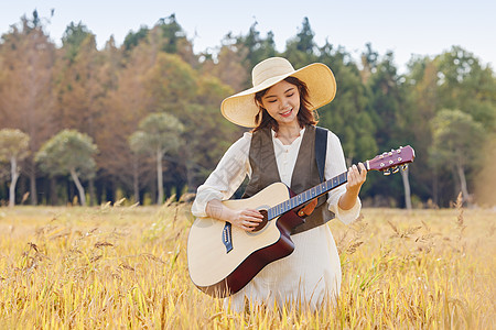 站在稻田里弹奏吉他的美女图片