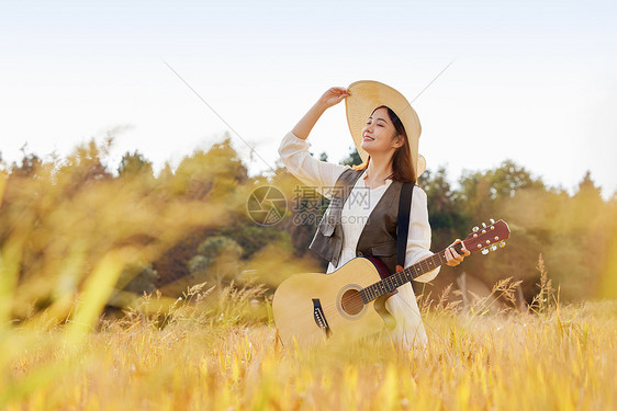 站在稻田里手拿吉他的美女图片