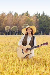 站在稻田里弹奏吉他的美女形象图片