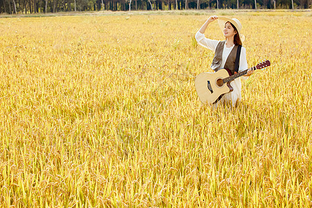 站在稻田里弹奏吉他的美女形象图片