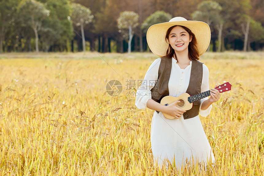 站在稻田里手拿尤克里里的美女图片