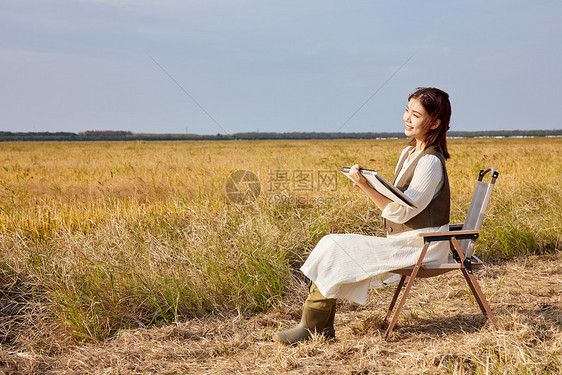 秋季在稻田里写生的美女图片